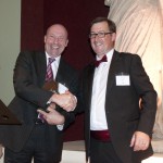 Andy Hill of Intelligent Ultrasound, left, receives his award from Jon Rees of OBN