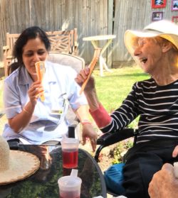 Care home resident and carer enjoying ice lollies