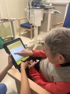 Woman signs on tablet device being held by another person out of picture